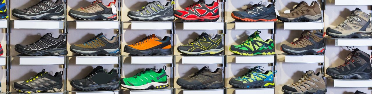 Image of big selection of sport shoes in market.